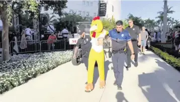  ?? Courtesy of Billy Corben ?? Miami police lead a protester away from Saturday’s unveiling of the Dogs and Cats Walkway and Sculpture Gardens, a path of painted cat and dog sculptures in Maurice A. Ferré Park next to the Pérez Art Museum Miami.