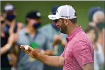  ?? MATT SLOCUM — THE ASSOCIATED PRESS ?? Jon Rahm holds up his ball after an eagle on the second hole during the final round of the Masters golf tournament on Sunday.