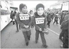  ??  ?? Protesters wearing masks of Park (right) and the president’s longtime friend Choi Soon-Sil (left) walk during a rally demanding her arrest near the presidenti­al house in Seoul. — AcP photo