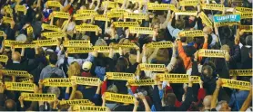  ?? (Albert Gea/Reuters) ?? PEOPLE HOLD BANNERS saying ‘Freedom for political prisoners,’ during a gathering in support of members of the dismissed Catalan cabinet, outside Barcelona’s town hall on Friday.