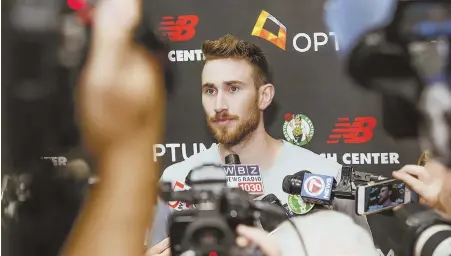  ?? STAFF PHOTO BY NICOLAUS CZARNECKI ?? TWO LEGS TO STAND ON: Gordon Hayward is surrounded by the media yesterday at the Auerbach Center in Brighton as the Celtics forward discusses his recovery from the horrific leg injury he suffered on opening night last season, one that looks healed and ready to go (below).