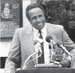  ?? Associated Press 1982 ?? Left: Huey Newton speaks from his jail cell in 1968. Right: Frank Robinson enters the Baseball Hall of Fame in 1982.