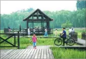  ?? ZHU ZHENQIANG / FOR CHINA DAILY ?? Tourists escape the summer heat at the Grand Canal Forest Park in Tongzhou, Beijing, in July.