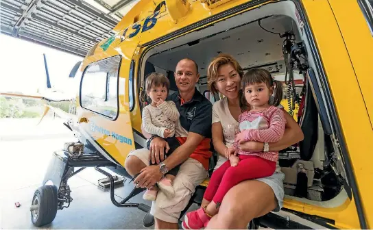  ?? PHOTO: SIMON O’CONNOR/STUFF ?? Grant ‘‘Axe’’ Rawlinson and his wife Stephanie show their twin 2-year-old daughters, Rachel, left, and Kate, the Taranaki Community Rescue Helicopter.