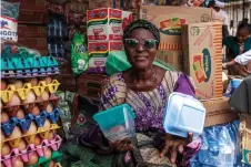  ?? ?? Kehinde holds various types of plastic plates in her store in Lagos.