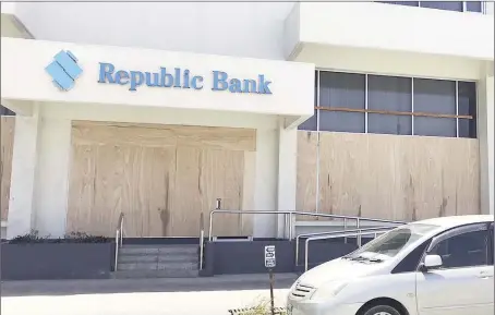  ??  ?? Plyboard was on Friday placed over the windows of Republic Bank’s Camp Street branch amidst unrest in several areas across the country that erupted from protests over disputed elections results