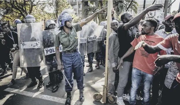  ?? PICTURE: GETTY IMAGES ?? 0 Zimbabwean anti riot police officers close the entrance to Rainbow Towers where the election’s results were announced