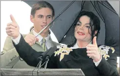  ??  ?? THUMBS UP: Michael Jackson with minder Matt behind