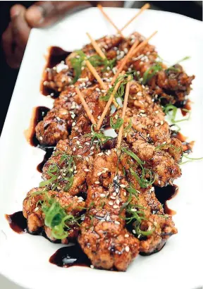  ?? HECTOR/PHOTOGRAPH­ER SHORN ?? Ashebre's sweet soy chicken satay topped with scallion curls, toasted sesame seeds.