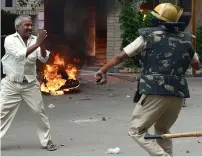  ?? AFP ?? Sect members overturn a media van in Panchkula, and ( right) a man pleads for his safety during clashes on Friday. —