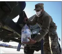  ?? (Arkansas Democrat-Gazette/Staton Breidentha­l) ?? Pfc. Terry Johnson with the Arkansas National Guard’s E Company, 39th Infantry Brigade Combat Team fills water bottles Monday in Benton as residents remain under a boil order after last week’s winter storms.
