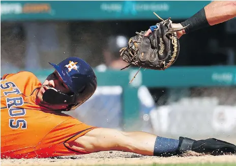  ?? PAUL SANCYA/THE ASSOCIATED PRESS ?? Carlos Correa of the Astros slides into home during Houston’s 5-4 win on Wednesday over the Tigers in Detroit.