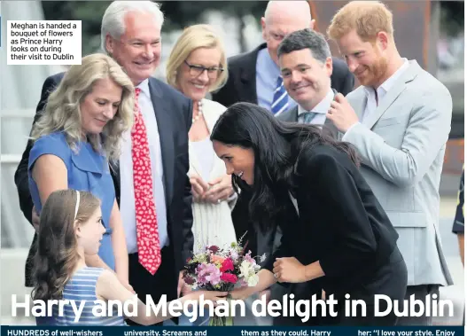  ??  ?? Meghan is handed a bouquet of flowers as Prince Harry looks on during their visit to Dublin