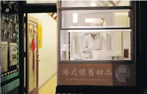  ??  ?? A woman in a dessert shop window makes dragon beard candy. Chinatown offers a dynamic side at night few may know about.