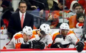  ?? KARL B DEBLAKER — THE ASSOCIATED PRESS FILE ?? Flyers interim head Scott Gordon, upper left, watches from the bench during the second period of a New Years Eve loss against the Carolina Hurricanes in Raleigh, N.C.