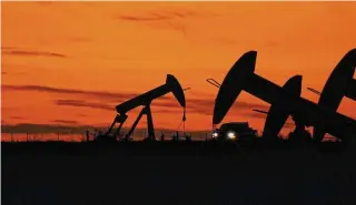  ?? Eric Gay/Associated Press ?? A truck passes oil pump jacks at dusk near Karnes City, Texas, in November 2023. The World Bank forecast Tuesday that the world economy would grow just 2.4% this year, down from 2.6% in 2023. The anti-poverty agency expects U.S. growth to decelerate to 1.6% this year as higher interest rates take a toll.