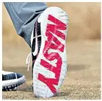  ??  ?? Up for the fight: Rory Mcilroy hits a tee shot, revealing the word ‘Nasty’ on the sole of his shoe, as he completed a round of 69