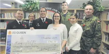  ??  ?? Members from HMCS Queen Naval Reserve Unit present donation cheque to the Moose Jaw Military Family Resource Centre (MFRC). From left: Lt(N) Kaytor, WO Dumais, LCdr Trent Nichols, LCol Paquette and CWO Hall with Dani Basley & Jeannette Hatta (front row).