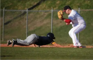  ??  ?? ABOVE: A slide back into first base was close but not enough to get the out against Troup County on March 15.