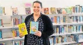  ??  ?? Librarian Kate Fairhurst holding some of the books available at the library.