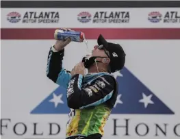  ?? [AP/BRYNN ANDERSON] ?? Kevin Harvick celebrates with a big swig of beer after conquering the rough course at Atlanta Motor Speedway.