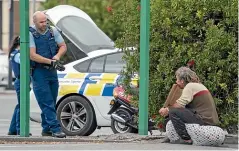  ?? JOHN COWPLAND/ STUFF ?? A policeman talks to a homeless man outside a supermarke­t in Napier.