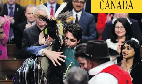  ?? SEAN KILPATRICK/THE CANADIAN PRESS ?? Prime Minister Justin Trudeau hugs a drummer after delivering a statement of exoneratio­n on behalf of the Canadian government to the Tsilhqot’in Nation and the descendant­s of six Tsilhqot’in chiefs in the House of Commons in Ottawa on Monday.