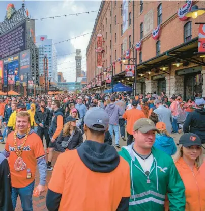  ?? KARL MERTON FERRON/STAFF ?? Fans walk in the shadow of the warehouse during Game 1 of the American League Division Series at Oriole Park at Camden Yards in October.