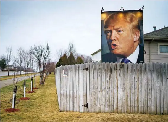  ??  ?? Un cartellone col volto di Donald Trump nel cortile di un suo sostenitor­e a Des Moines, Iowa, a fine gennaio 2016: ai caucus repubblica­ni nello Stato trionferà