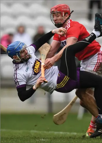  ??  ?? Wexford netminder Mark Fanning is heavily tackled by Cork captain Bill Cooper during Sunday’s league tie