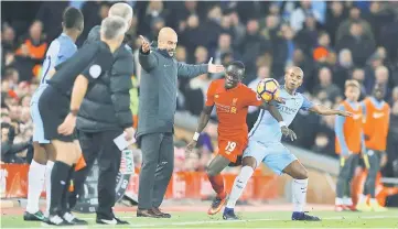  ??  ?? File photo shows Liverpool’s Sadio Mane in action with Manchester City’s Fernandinh­o as Manchester City manager Pep Guardiola looks on. — Reuters photo
