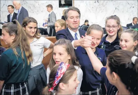  ?? Drew Angerer Getty Images ?? BRETT KAVANAUGH takes a break Thursday from his confirmati­on hearing with former players of a youth basketball team he coached.