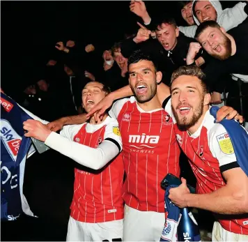  ??  ?? Cheltenham Town celebrate outside the ground with fans following their promotion to League One