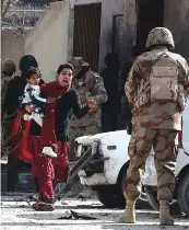  ?? — AFP ?? Pakistani Christians are evacuated by security personnel from a Methodist church after a suicide bomber attack during a Sunday service in Quetta on Sunday.