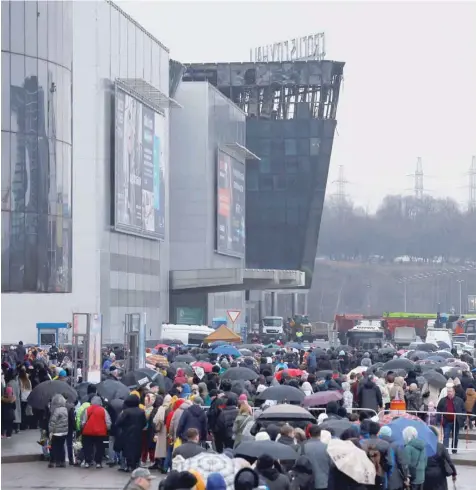  ?? — Reuters ?? People line up to lay flowers at a makeshift memorial to the victims of a shooting attack set up outside the Crocus City Hall concert venue in Moscow.