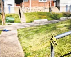  ?? LEA SKENE/BALTIMORE SUN ?? A piece of police tape is left near a shooting scene in the 800 block of Gretna Court where a man and woman were killed.