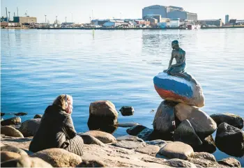  ?? IDA MARIE ODGAARD/RITZAU SCANPIX ?? The colors of the Russian flag are painted Thursday on the stone that supports the statue of Hans Christian Andersen’s “Little Mermaid” after it was vandalized. The 5-foot-high statue, one of Copenhagen’s biggest tourist draws, sits at the entrance of the city’s harbor in Denmark. It was not known when the vandalism took place.