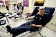  ?? RUDY GUTIERREZ/ASSOCIATED PRESS ?? Carlos Flores, foreground, donates blood at the United Blood Services blood bank in El Paso on Saturday. “We need to pull together and help people in need,” he said.
