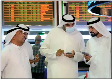  ?? (AP/Ebrahim Noroozi) ?? Traders talk Tuesday on the floor of the Dubai Financial Market in Dubai, United Arab Emirates, after the public stock listing of Dubai’s Water and Electricit­y Authority.