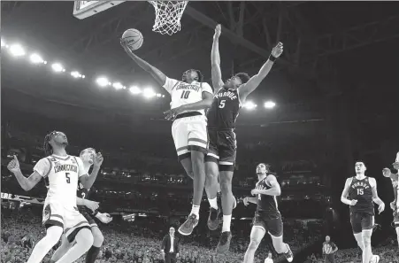  ?? AP ?? UConn’s Hassan Diarra rises for a layup past Purdue’s Myles Colvin during the NCAA college Final Four championsh­ip game on Monday in Glendale, Arizona. UConn won 75-60 to become the first team since 2007 to capture back-to-back NCAA titles.