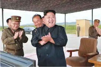  ??  ?? NORTH KOREAN LEADER Kim Jong Un applauds the launch of a Hwasong-12 missile in this undated photo released by North Korea’s Korean Central News Agency on Sept. 16.