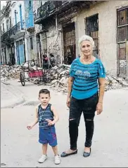  ?? FLAVIA COMPANY ?? Edificios enprecario. Mauro, de dos años, y su abuela frente a los escombros tras el derrumbe que sufrió su casa