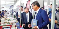  ?? MOEYS* ?? Education minister Hang Chuon Naron examines books during the 8th National Reading Day, celebrated in March last year.