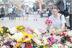  ?? REUTERS ?? A woman pays her respects and lays flowers at the scene of Saturday’s mass stabbing at Bondi Junction, Sydney, Australia.