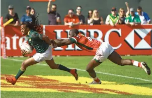  ?? Photo by Shihab ?? South African player tries dodge a Kenyan during the World rugby Sevens Series. —