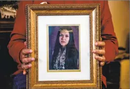  ?? ?? JUDY RISLING holds a photograph of daughter Emmilee, who was last seen on a bridge in a densely forested area of the Yurok reservatio­n in mid-October 2021.