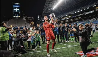  ?? JOVELLE TAMAYO/THE NEW YORK TIMES ?? Seattle Sounders FC goalkeeper Stefan Frei, the tournament’s most valuable player, raises the championsh­ip cup Wednesday. Winning the CONCACAF Champions League title qualifies the team for the FIFA Club World Cup, a tournament stacked with soccer royalty.