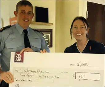  ??  ?? Garda Dermot Fearon presenting a cheque for €1,021 to his wife Karen Fearon of the CNM2 Oncology Unit at Sligo University Hospital. Dermot ran 36km from Dromohair to Coolaney in July to raise funds for the SHOUT and was raised mostly from Garda personnel in Sligo Station.