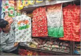  ?? —BL SONI ?? A shopkeeper shows jackets, flags and t-shirts of various political parties in Lalbaug, Mumbai.