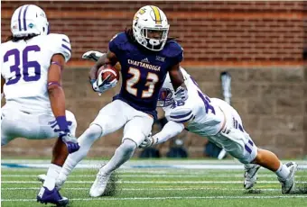  ?? STAFF PHOTO BY DOUG STRICKLAND ?? Furman linebacker Wade Smith, rear, and cornerback Bradford Lemmons close in on UTC running back Richardre Bagley during Saturday’s game. Furman held the Mocs to 7 rushing yards and won 41-17.